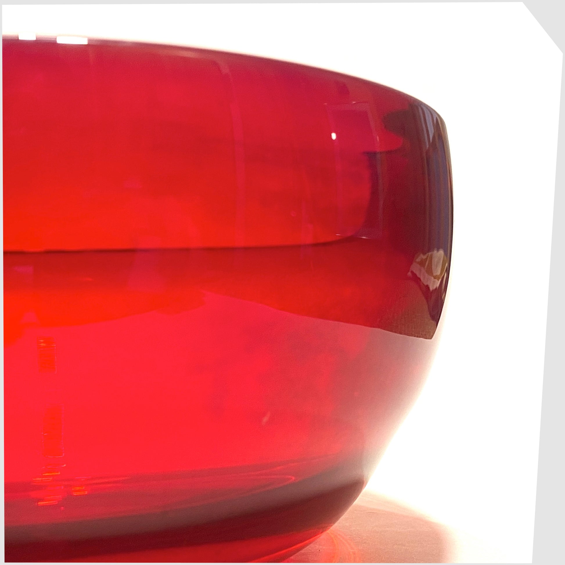Close up of the Whitefriars Glass Optical Bowl in ruby red glass, shown on a white background