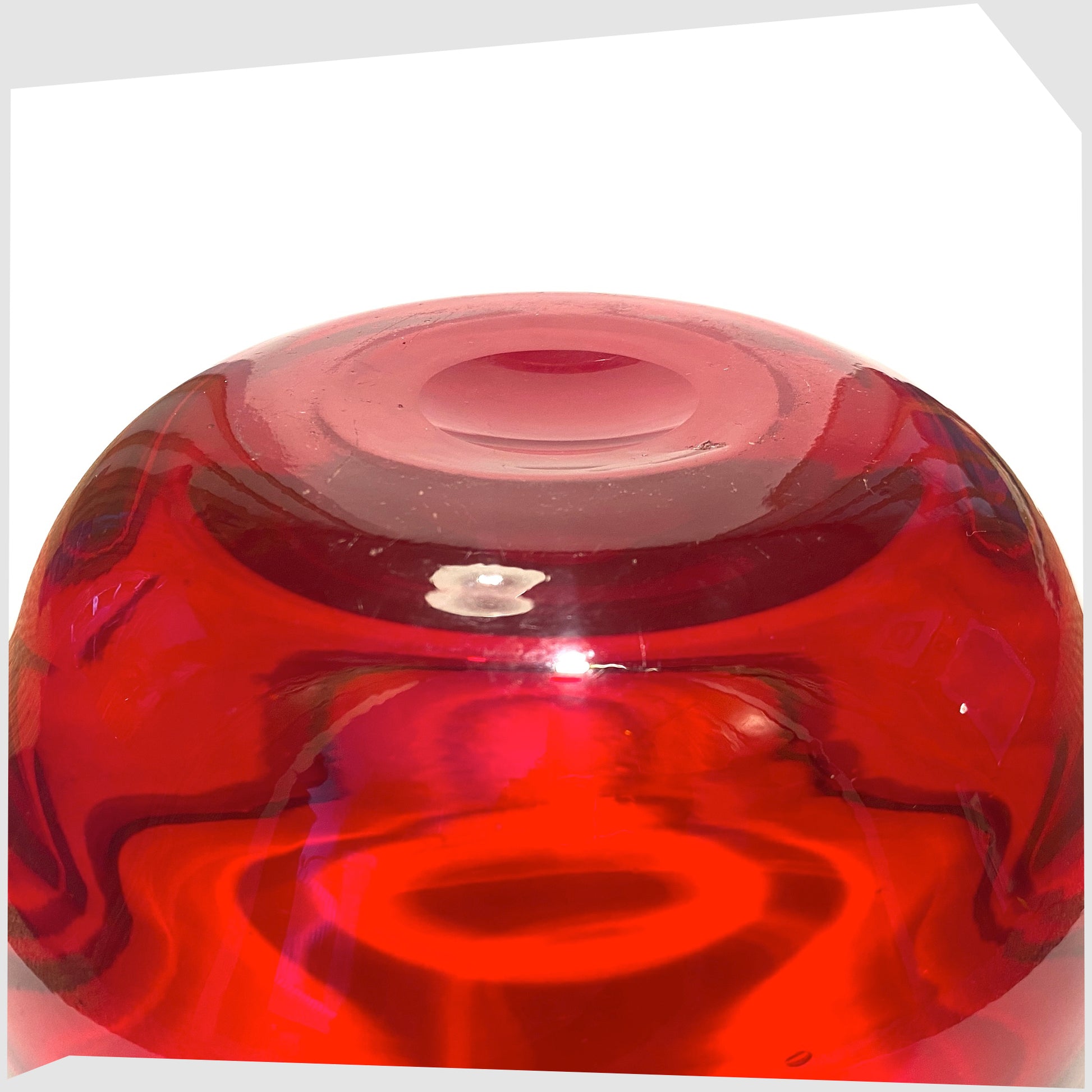 Pontil mark on the base of the Whitefriars Glass Optical Bowl in ruby red glass, shown on a white background