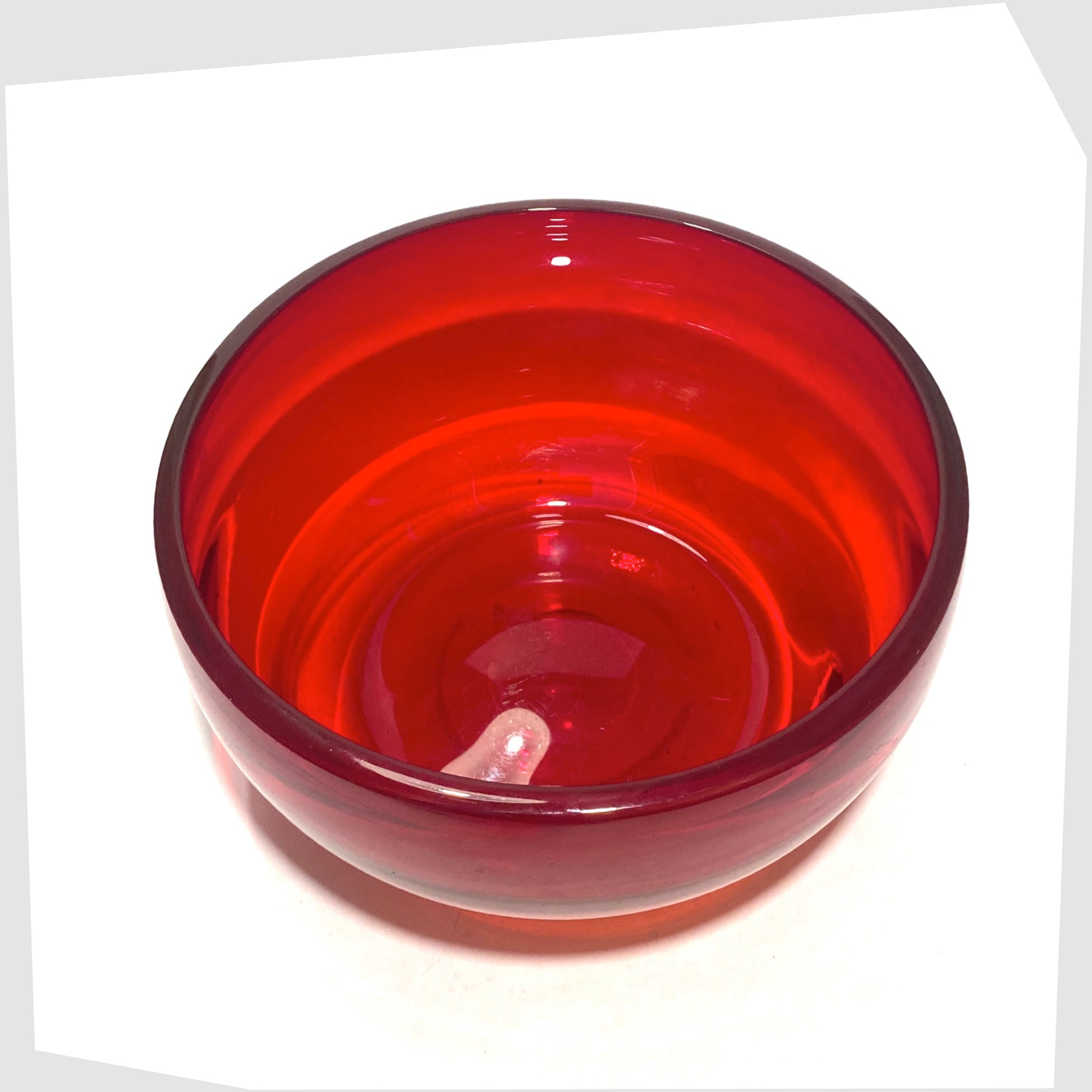 inside of the Whitefriars Glass Optical Bowl in ruby red glass, shown on a white background